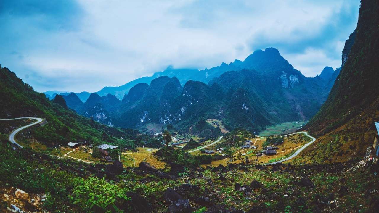 A winding road snakes through a valley on the epic Ha Giang Loop.