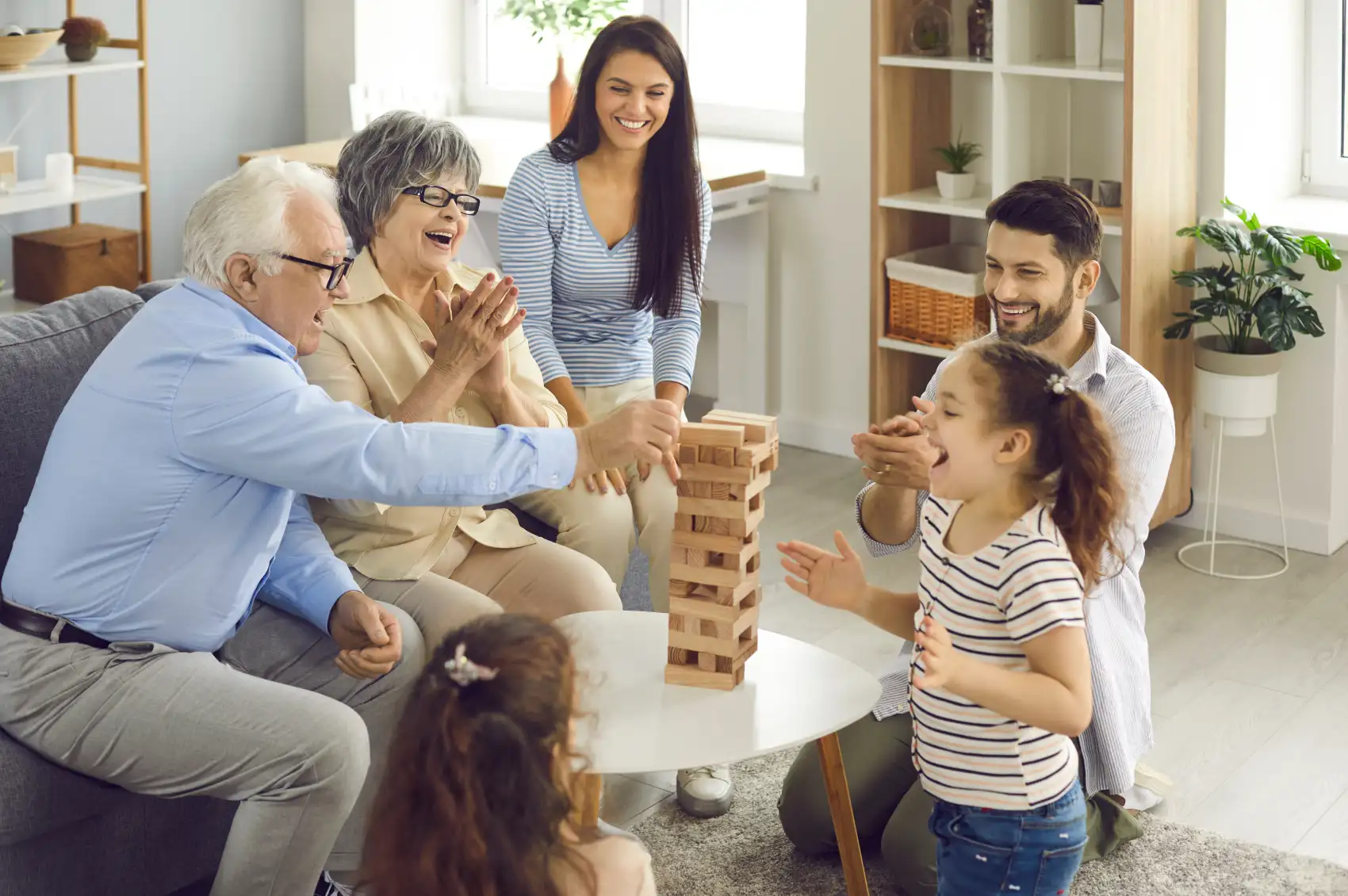 Trois générations d’une famille jouent à un jeu de société, illustrant la vie avec l’épilepsie à tout âge