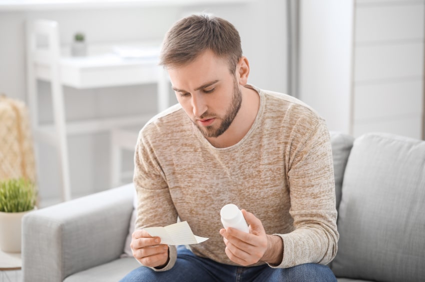 Personne prenant une pilule dans un flacon