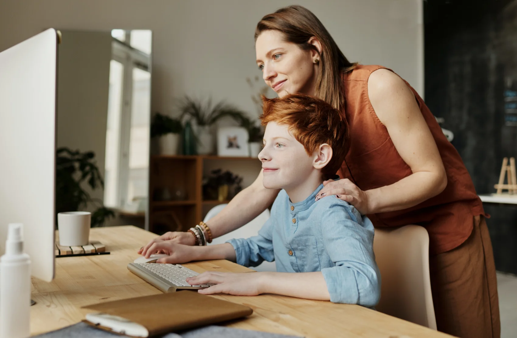 Une mère et son fils apprenant ensemble sur un ordinateur les causes de l’épilepsie chez l’enfant