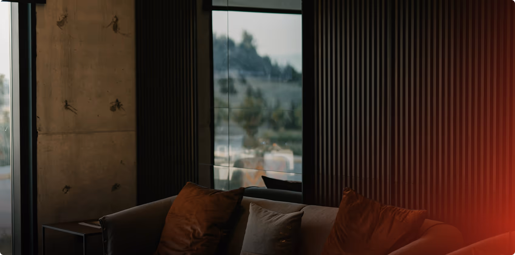 Elegantes Wohnzimmer mit Panoramafenstern, Sofa und Blick auf Berglandschaft. Text 'SCHAUEN. BAUEN. VERTRAUEN.' und 'Sprechen Sie mit uns über Ihr Projekt'