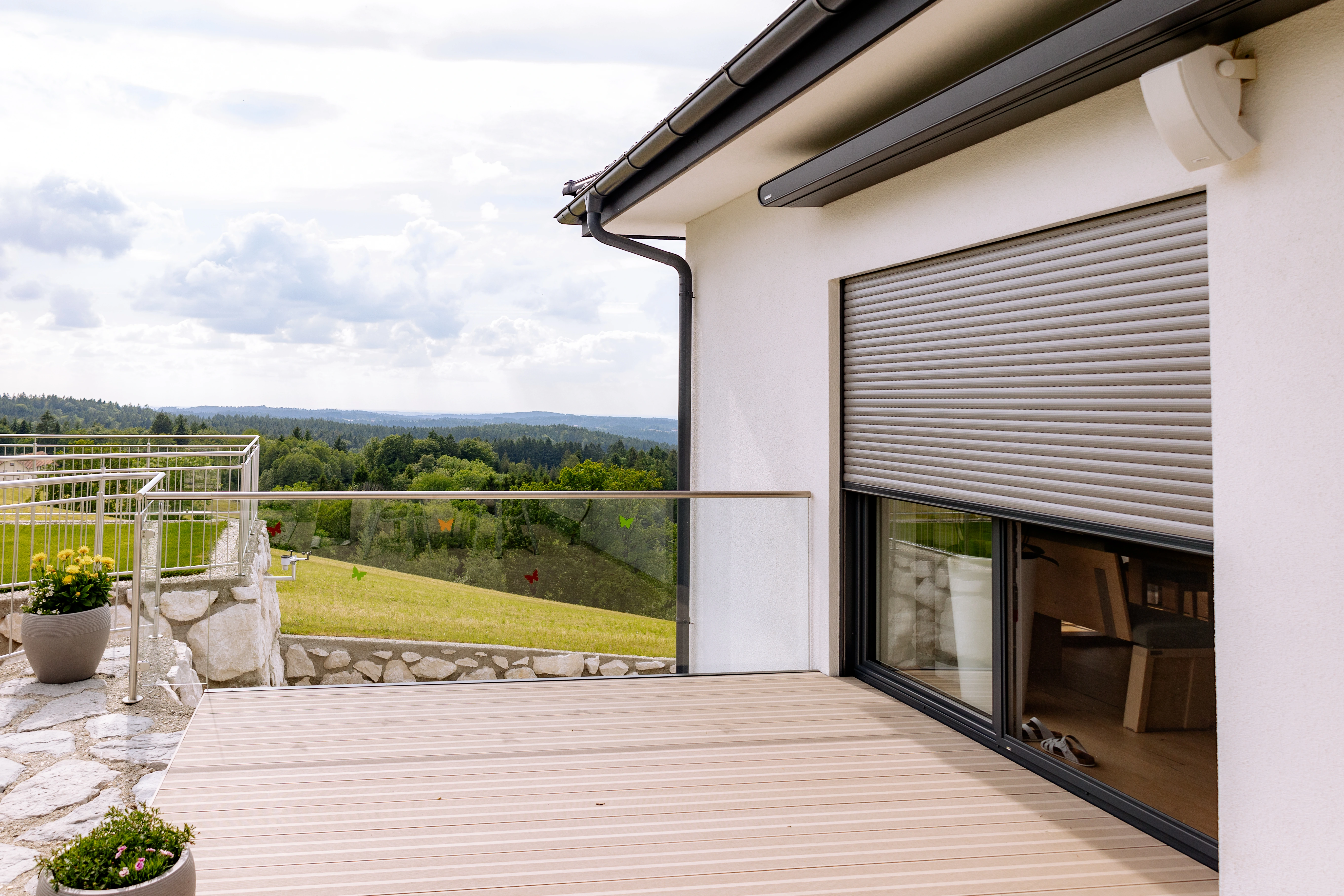 Elektrischer Rollladen an moderner Terrassentür mit Aluminium-Führungsschienen – hochwertiger Außenrollladen als effektiver Sonnenschutz, Sichtschutz und Einbruchschutz für Fenster und Balkontüren im Neubau.