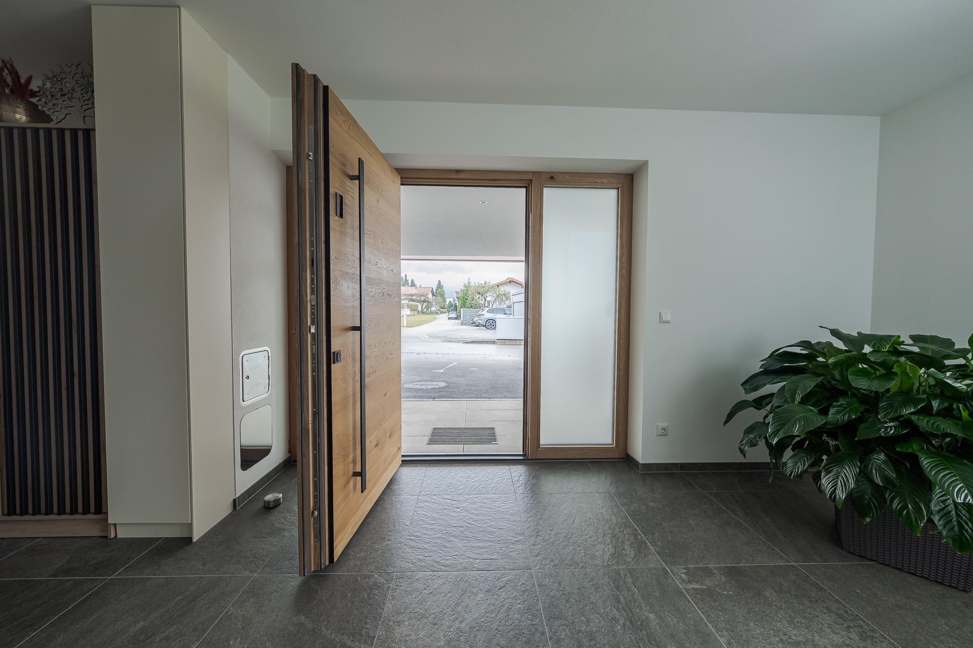 Innenansicht einer modernen Holz-Haustüre mit Seitenteil und Edelstahl-Stoßgriff – hochwertige, einbruchhemmende Eingangstür mit Wärmedämmung, Sicherheitsschloss und zeitlosem Design für Neubau oder Sanierung.