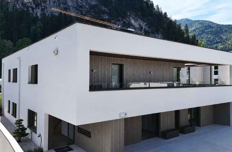 Modernes Wohngebäude mit großen Fensterflächen, Holzfassade und Balkon in alpiner Lage – hochwertige Fensterlösungen von SR.Schauraum.