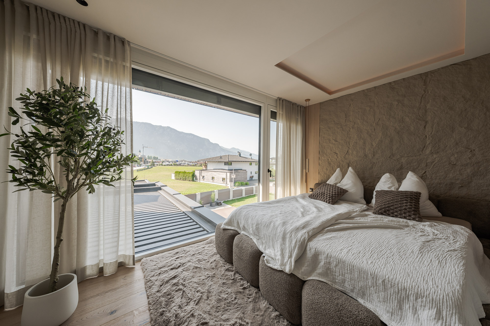 Modernes Schlafzimmer mit großflächigen Fenstern und Bergblick – hochwertige Fensterlösung von SR.Schauraum in Tirol