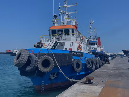 A blue crewboat with the word dynamic on the side.