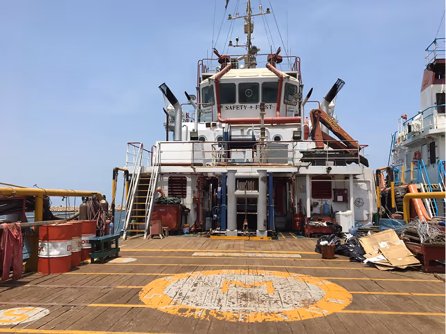 A large white and red ship with a yellow circle on the deck.