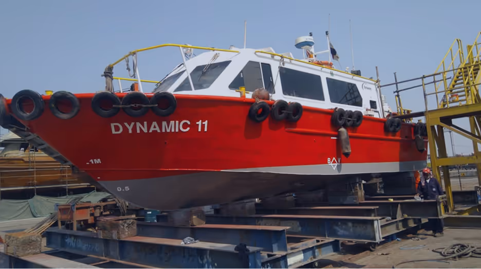 A red and white boat with the word dynamic on the side.