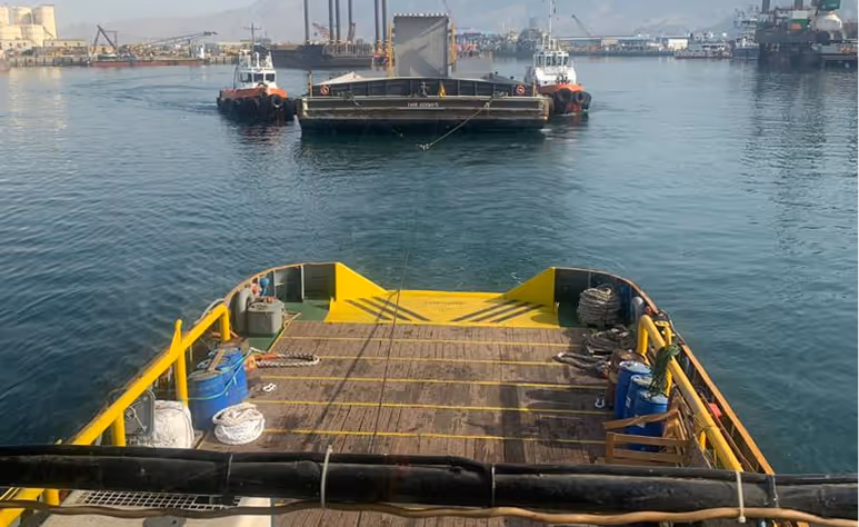 A boat with a yellow ramp on the back.