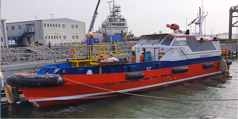 A red and blue boat with a crane on it.