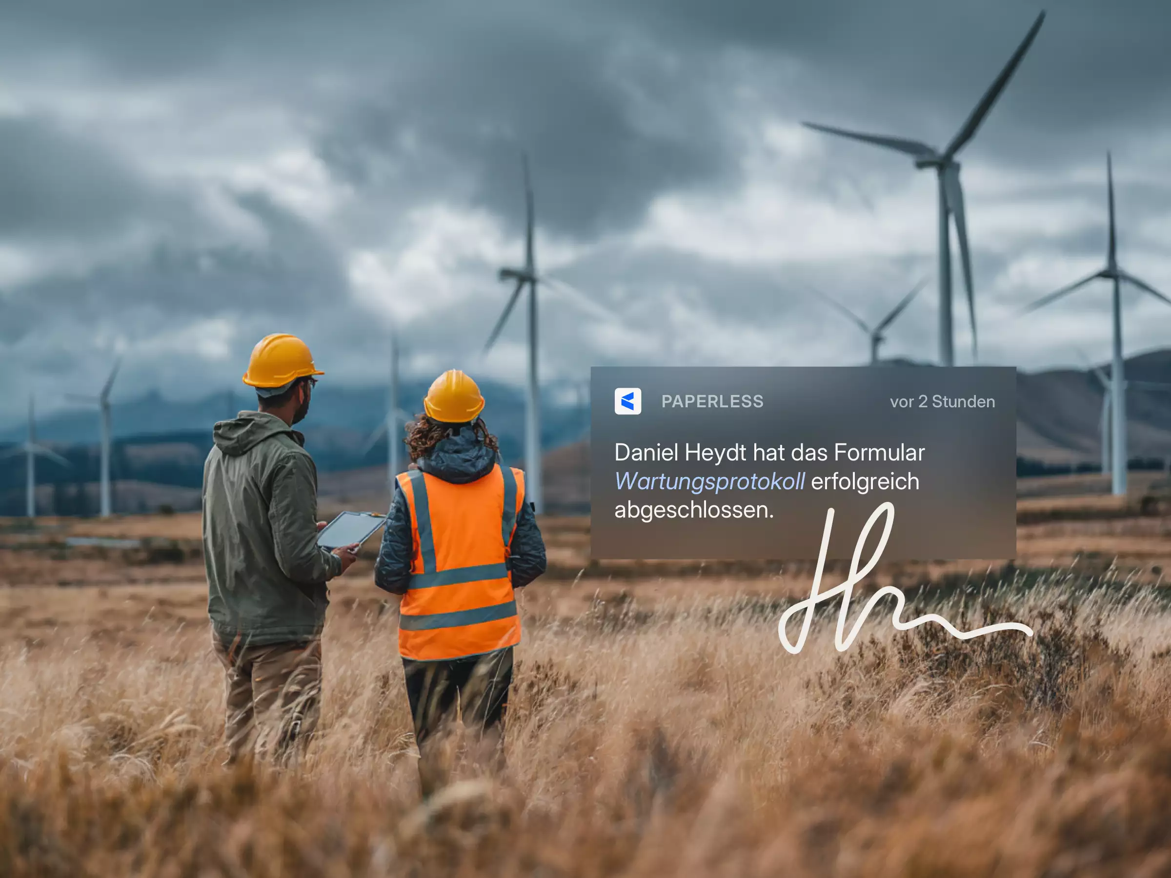 Zwei Ingenieure mit Schutzhelmen und Warnweste stehen auf einem Feld mit Windturbinen und überprüfen ein Tablet, daneben eine Bildschirmnachricht über abgeschlossene Wartungsprotokolle.