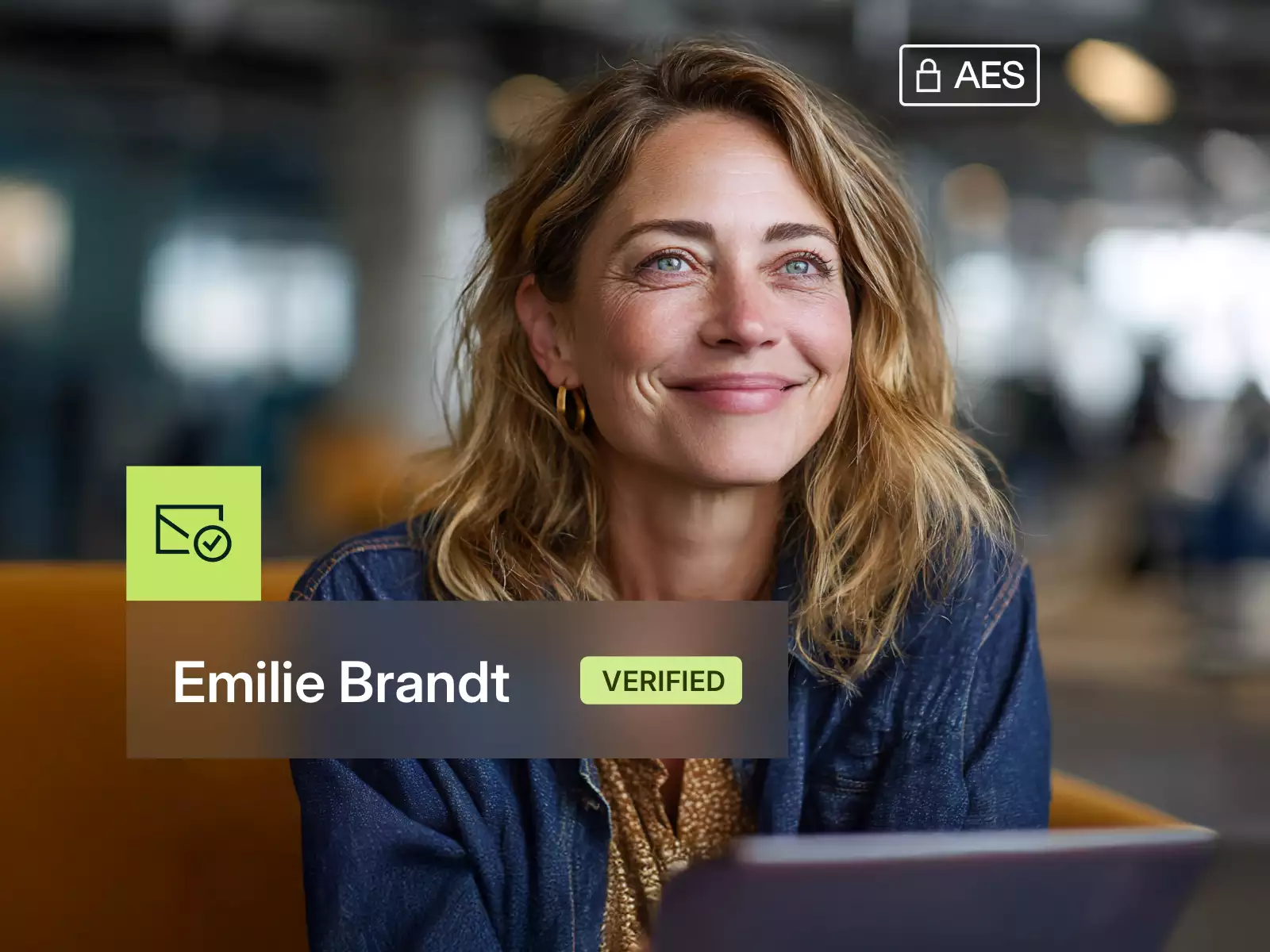 Smiling woman with blond hair and denim jacket in a modern office, shown as Emilie Brandt with verified status.