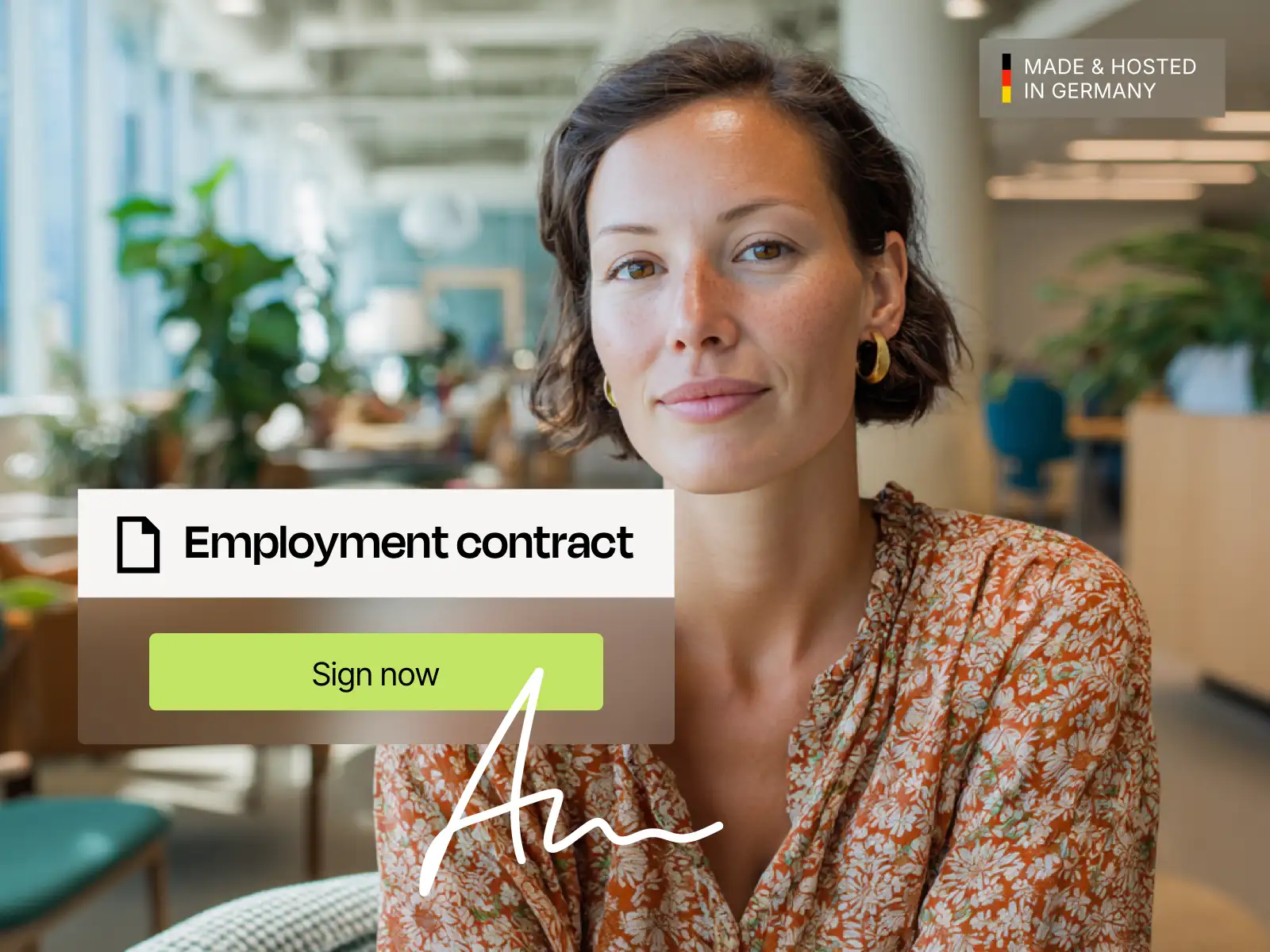 Portrait of a woman in a bright office with a digital employment contract and the “sign” button on the screen.