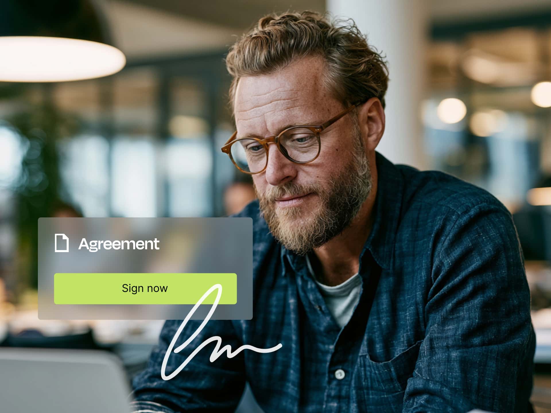 Portrait of a smiling man with short hair and glasses, wearing a blue shirt, with a “Sign” button on a transparent overlay titled “Agreement”