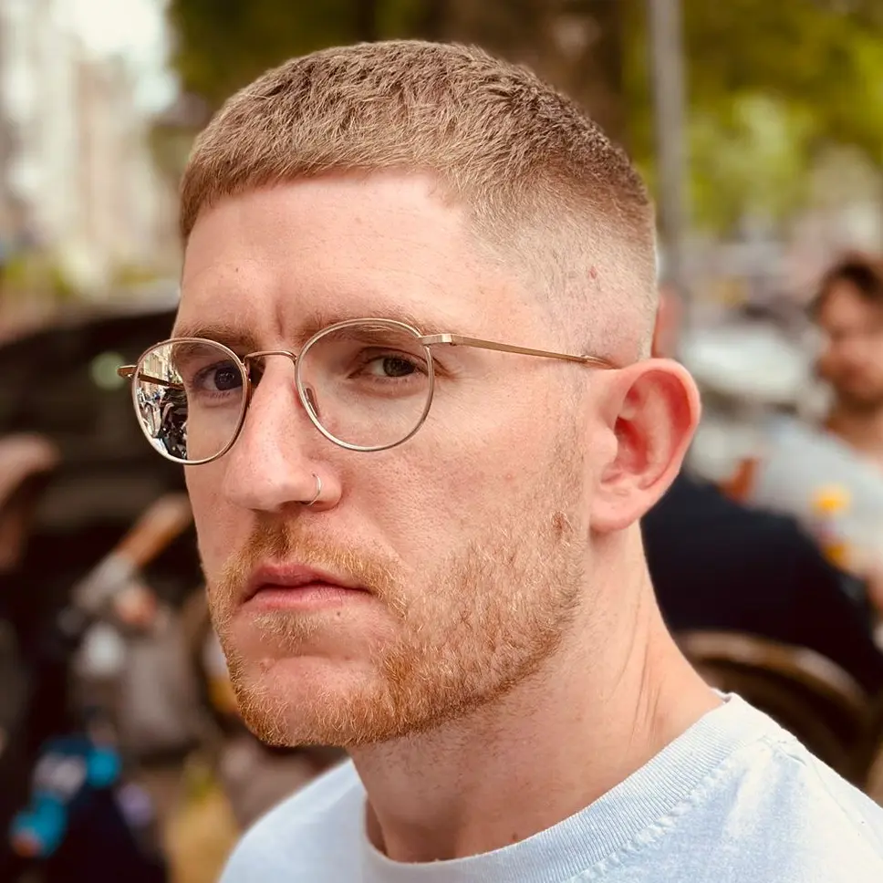 Portrait of a man in a white shirt, facing forward and smiling slightly, set against a plain white background.