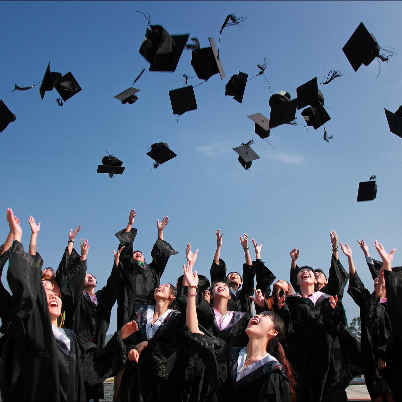 Graduates celebrating by throwing their caps in the air