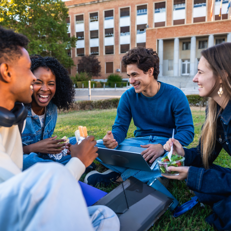 Diverse group of students laughing together outdoors
