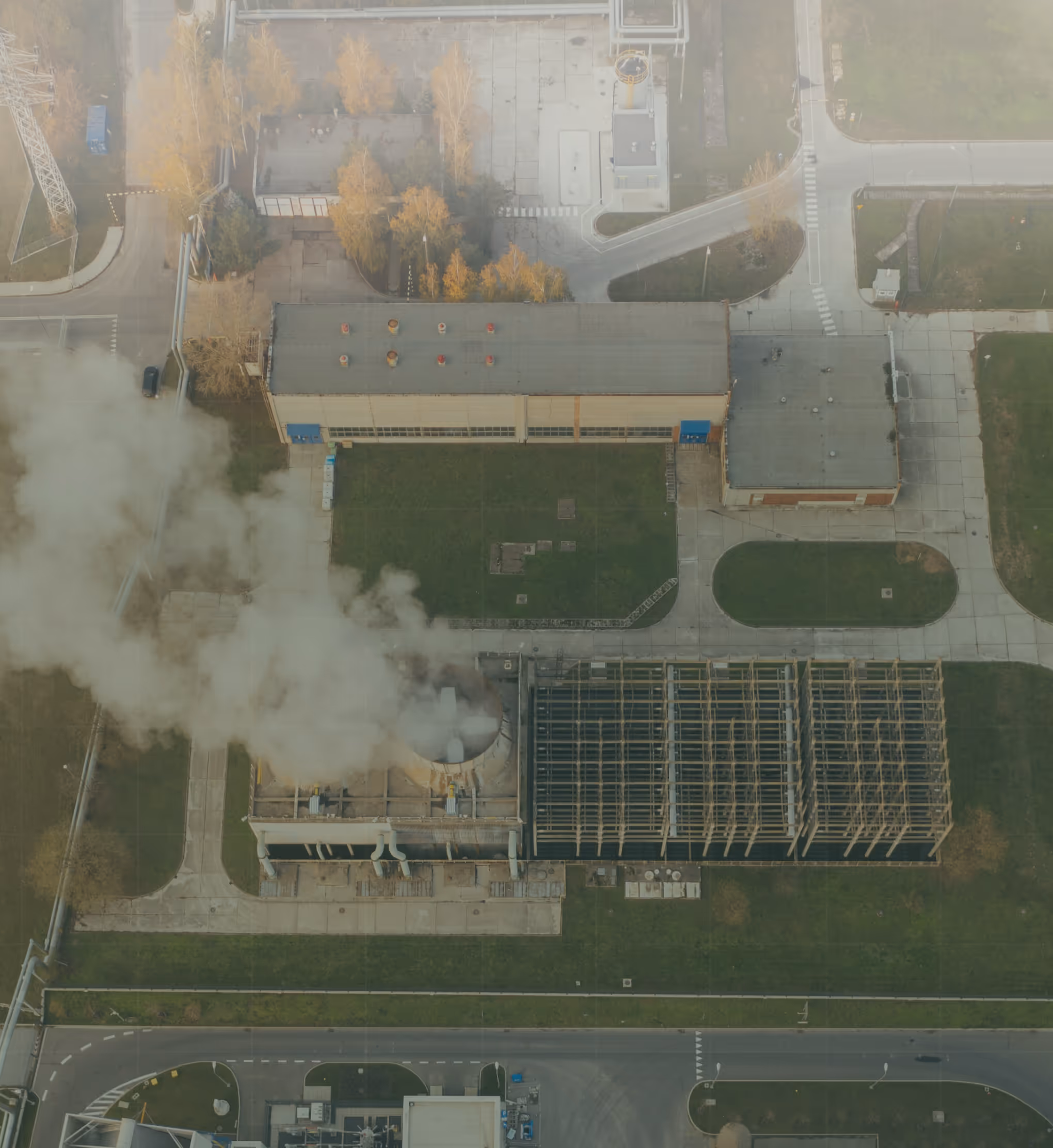 Aerial view of industrial facility with smoke emissions, showcasing AI-powered anomaly detection for precision monitoring of power plants, utilities, and high-risk infrastructure assets.