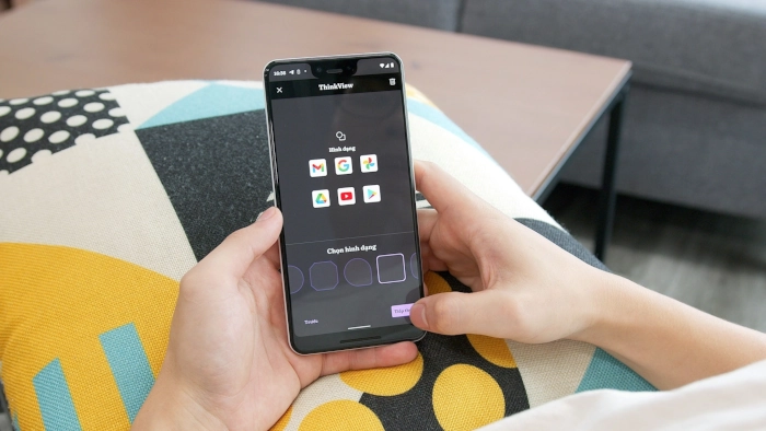 Dvě ruce drží chytrý telefon s aplikacemi od google