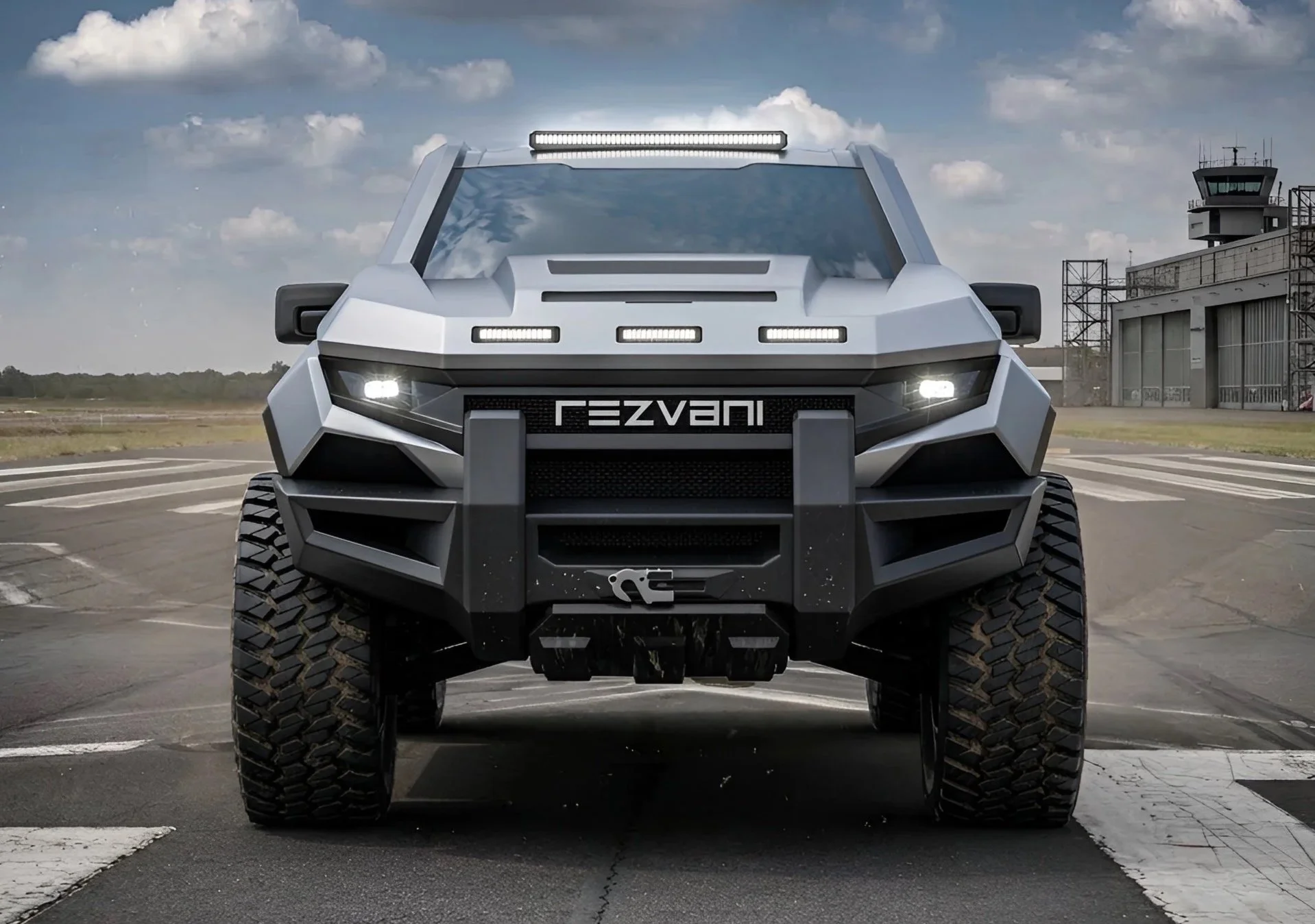 Detailní čelní pohled na drsný pickup Rezvani Fortress se svítícími LED světlomety a integrovaným navijákem v předním nárazníku.