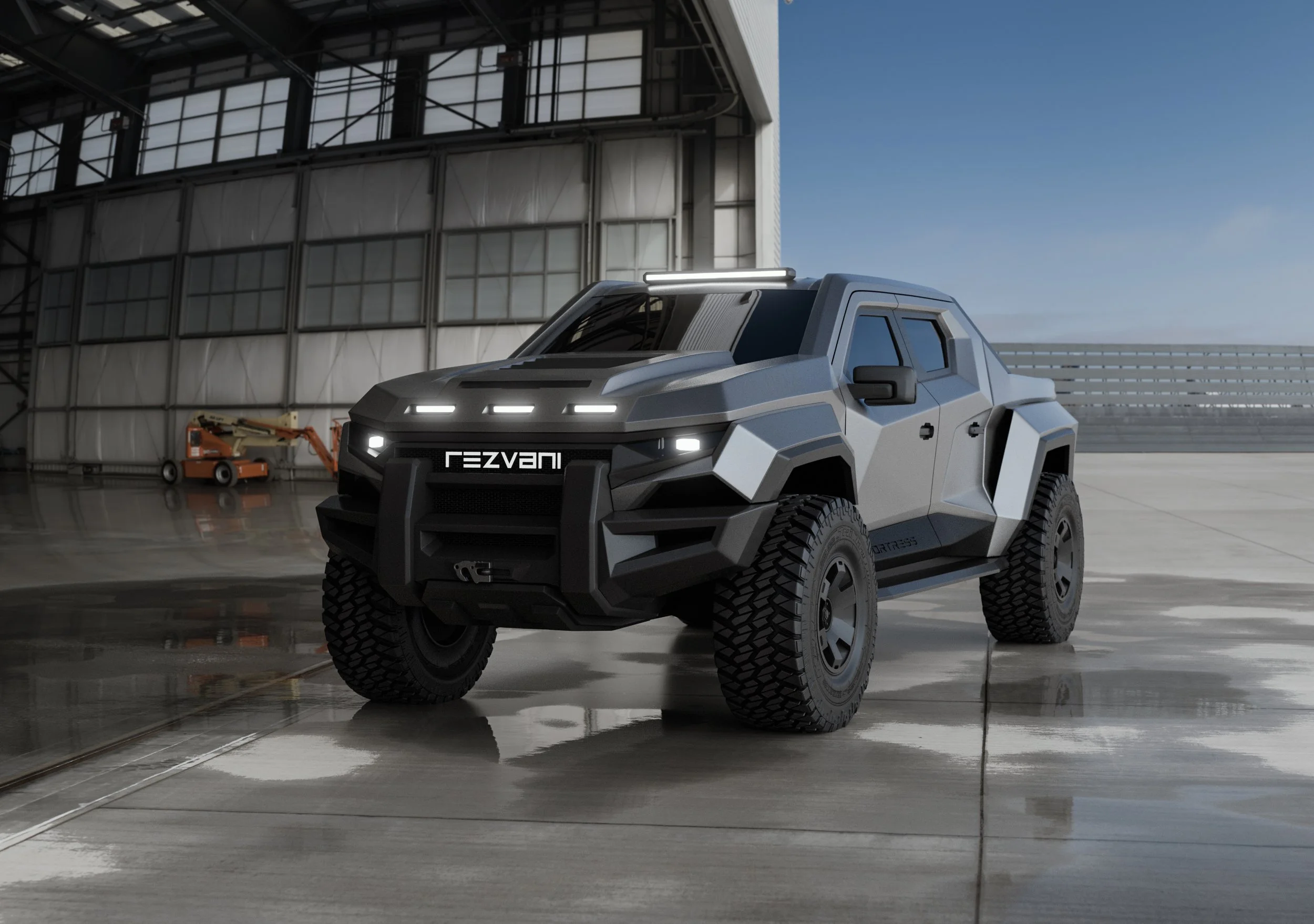 Šedý taktický truck Rezvani Fortress focený zepředu z boku na betonové ploše před velkým bílým letištním hangárem.