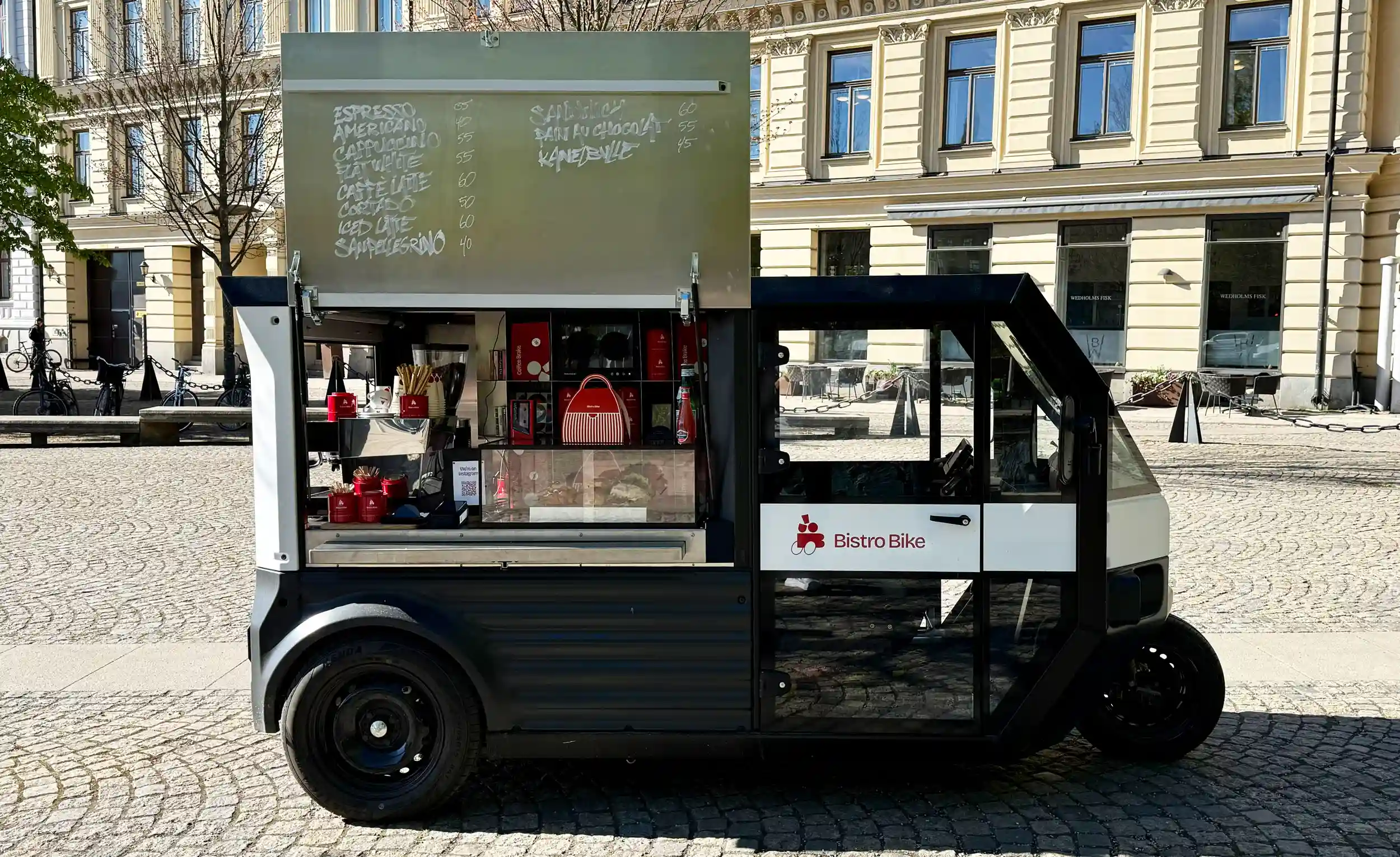 Verze EVIG Event s vyklopenými dveřmi sloužící jako stylová osvětlená kavárna v ulicích města.