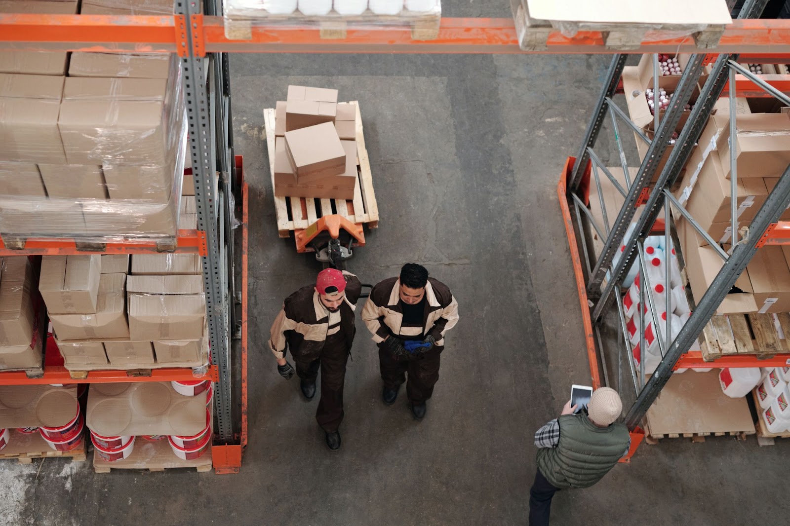 Two warehouse associates collect orders using a WMS 