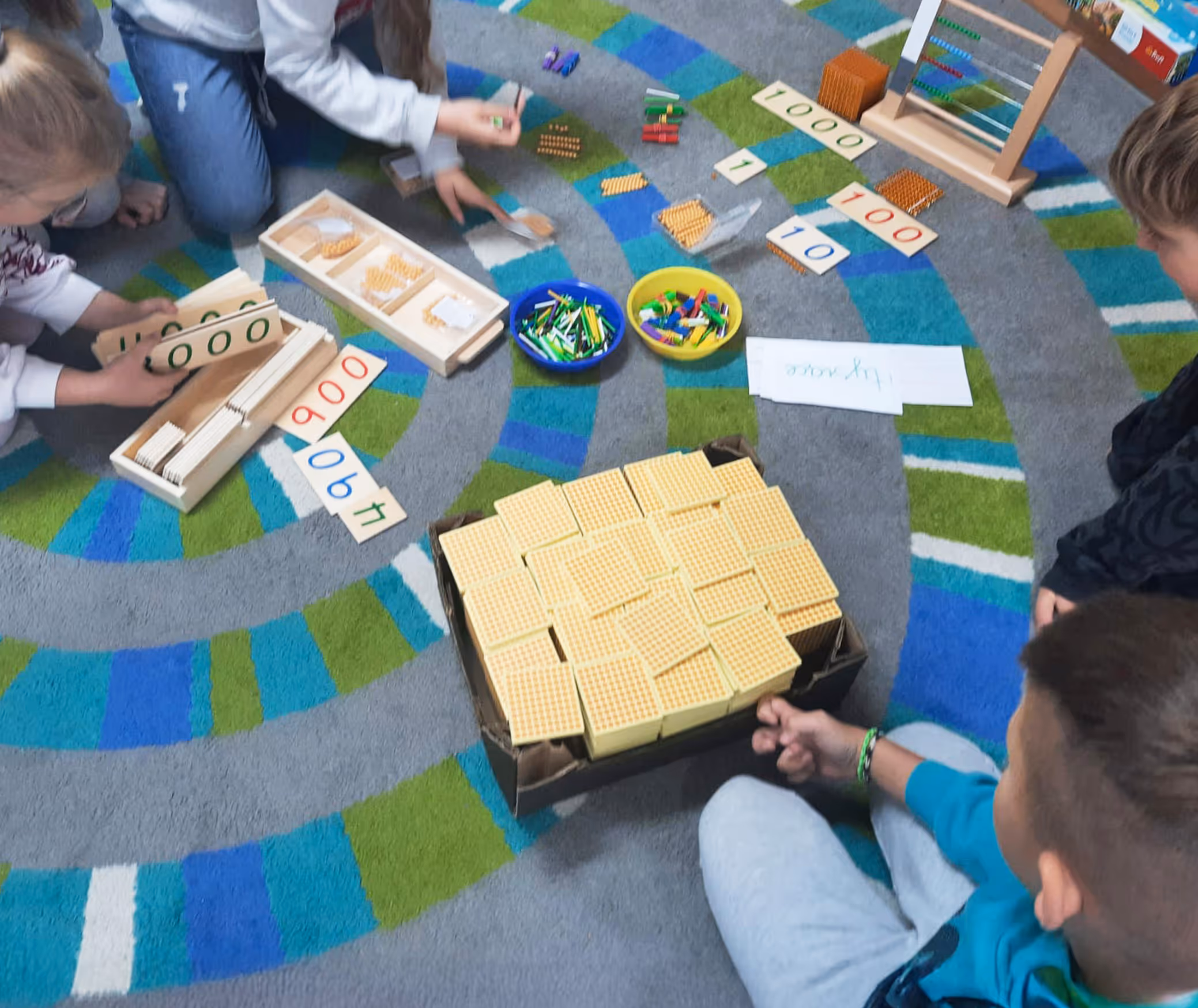 Dzieci robią obliczenia z wykorzystaniem małego liczydła