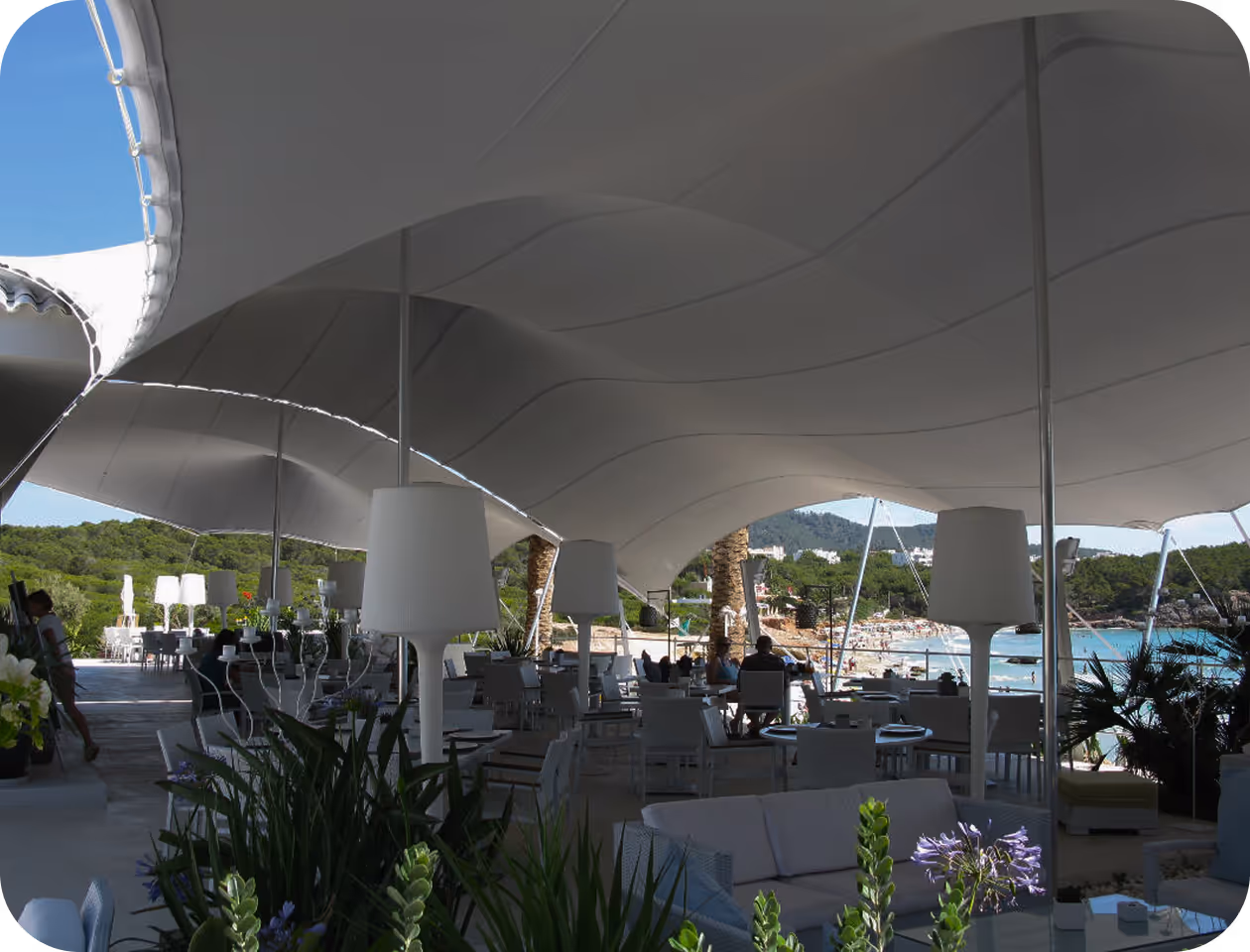 A large white tent with tables and chairs under it.