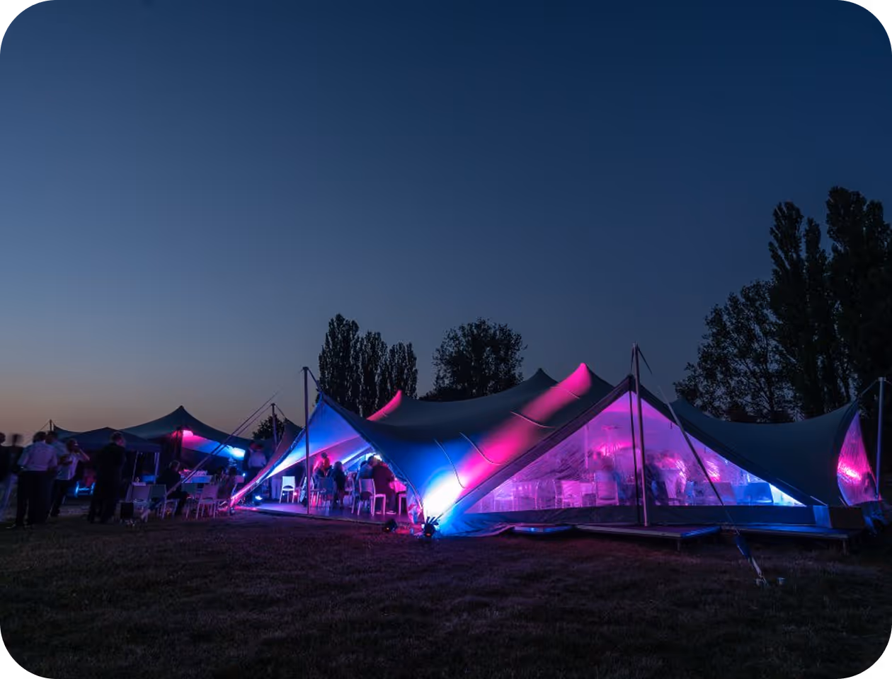A group of tents lit up at night.