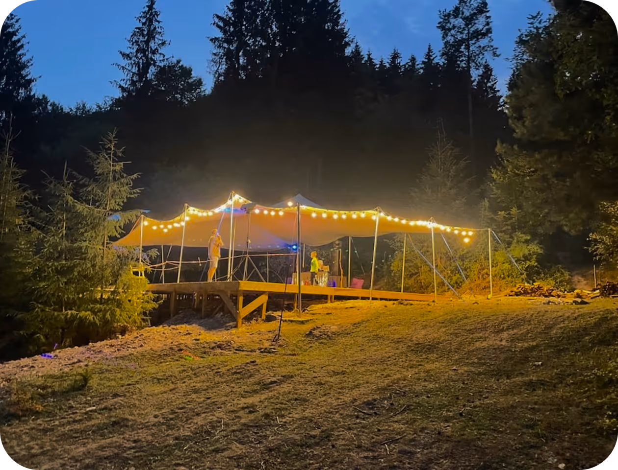 A tent set up in the middle of a forest.