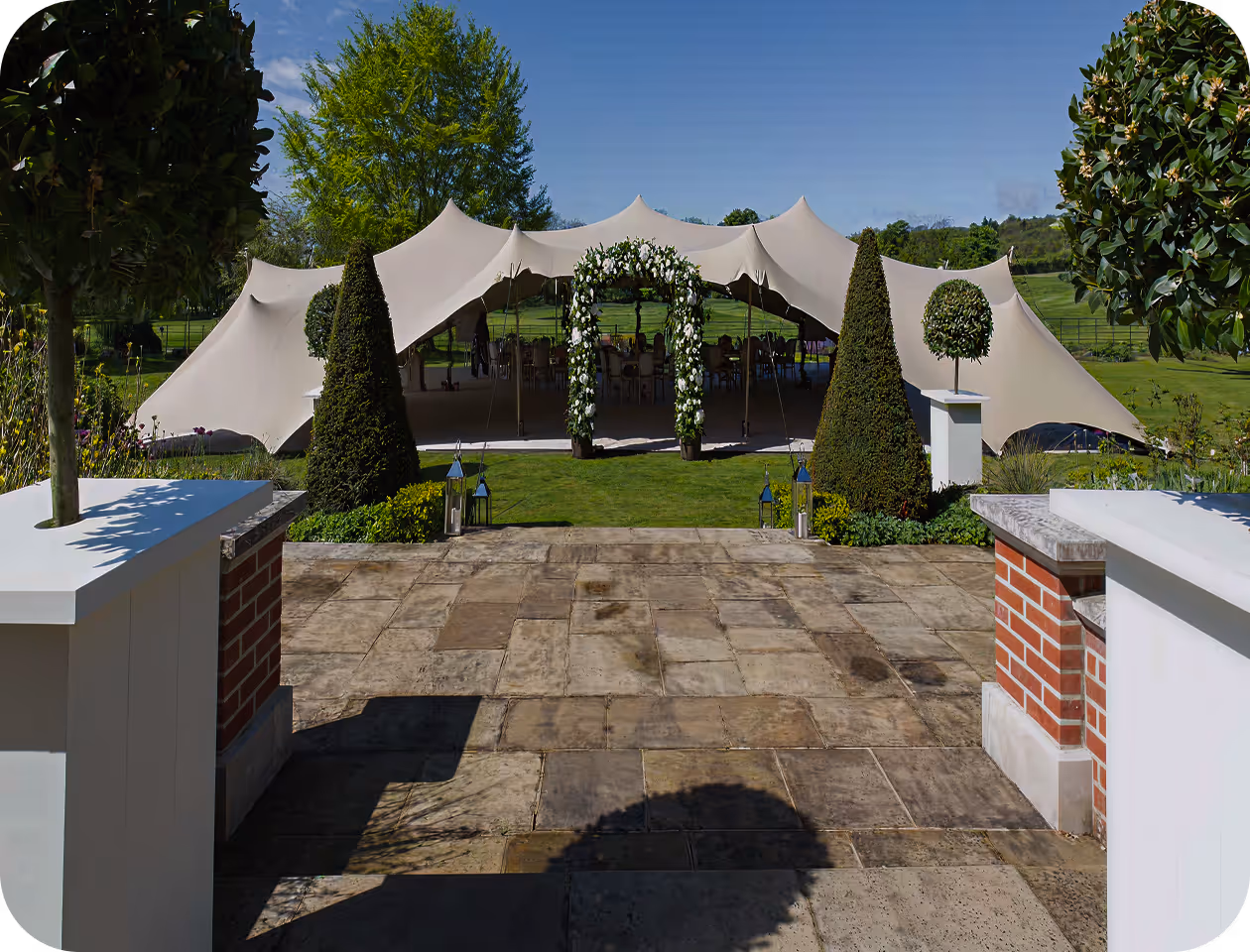 A large white tent set up in the middle of a park.
