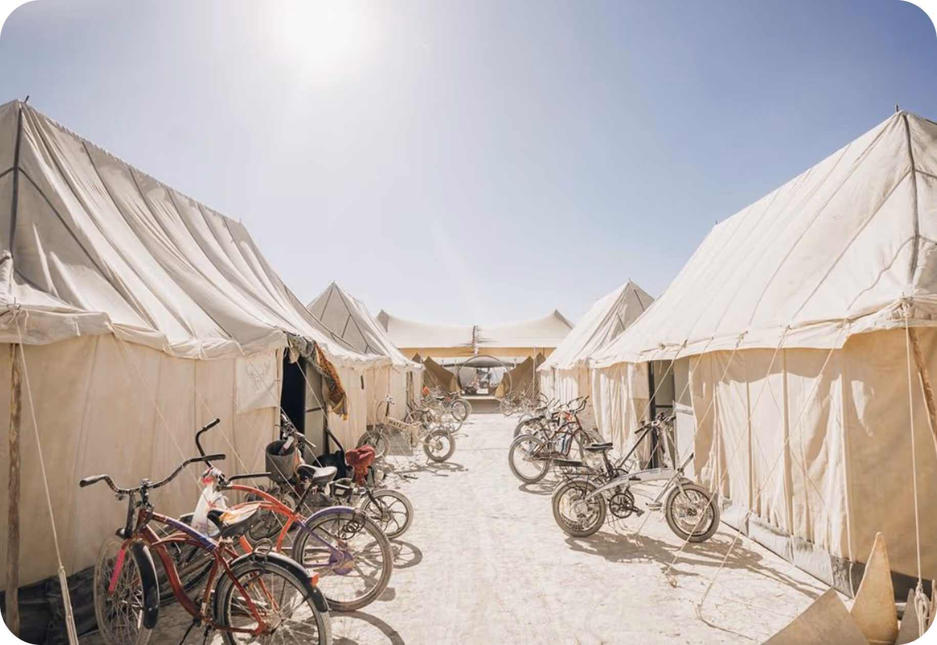 A group of bikes parked in front of tents.