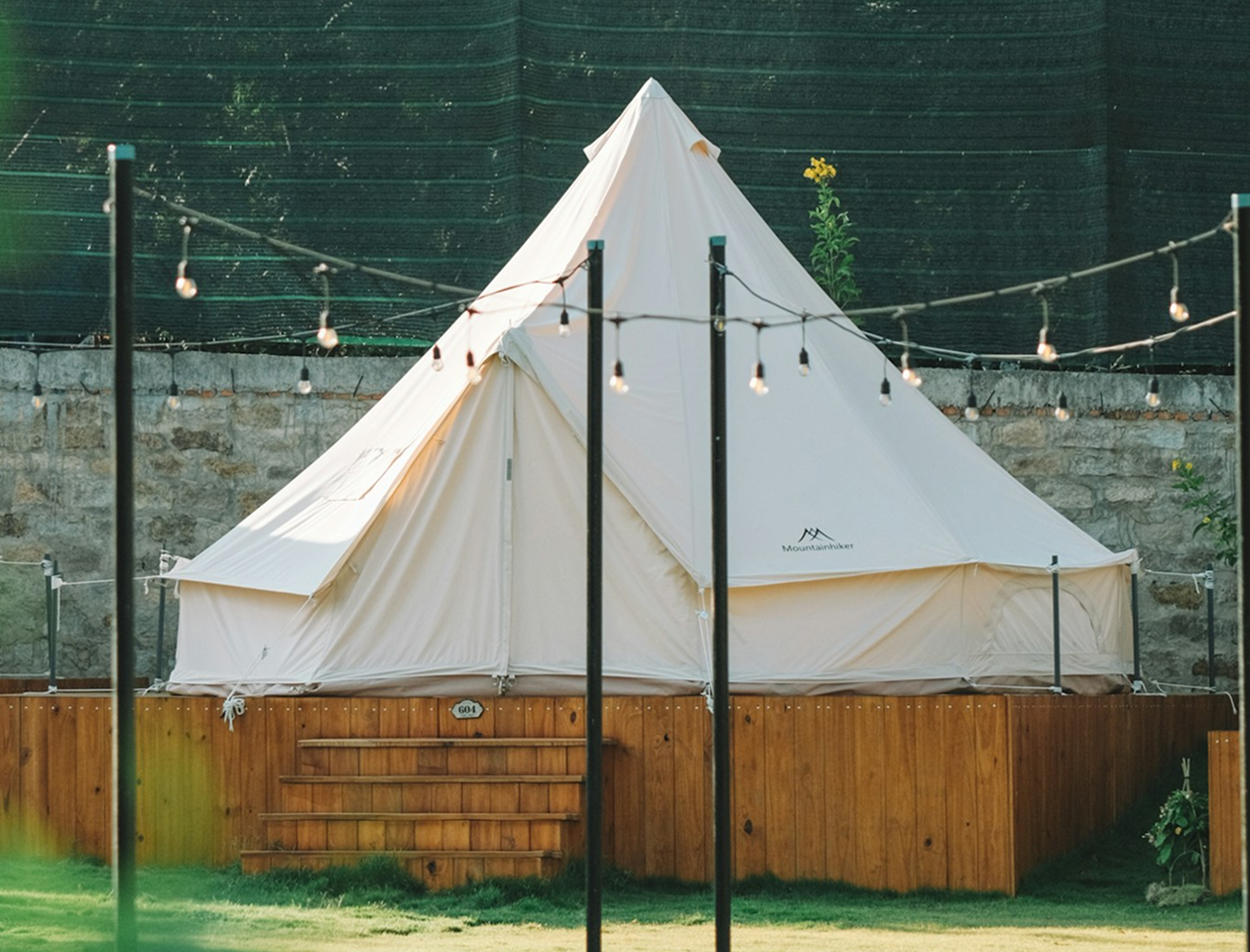A large white tent sitting on top of a lush green field.