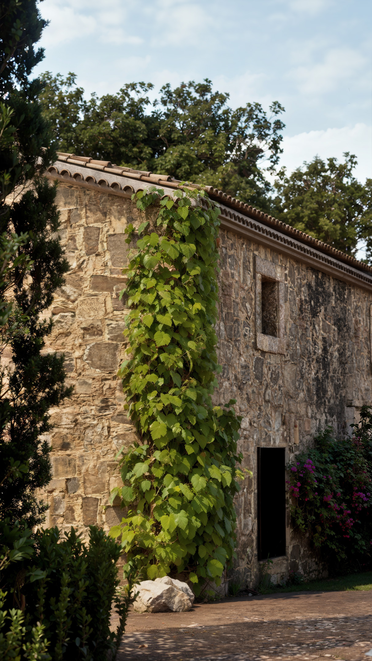 Main exterior view of stone house with natural surroundings.