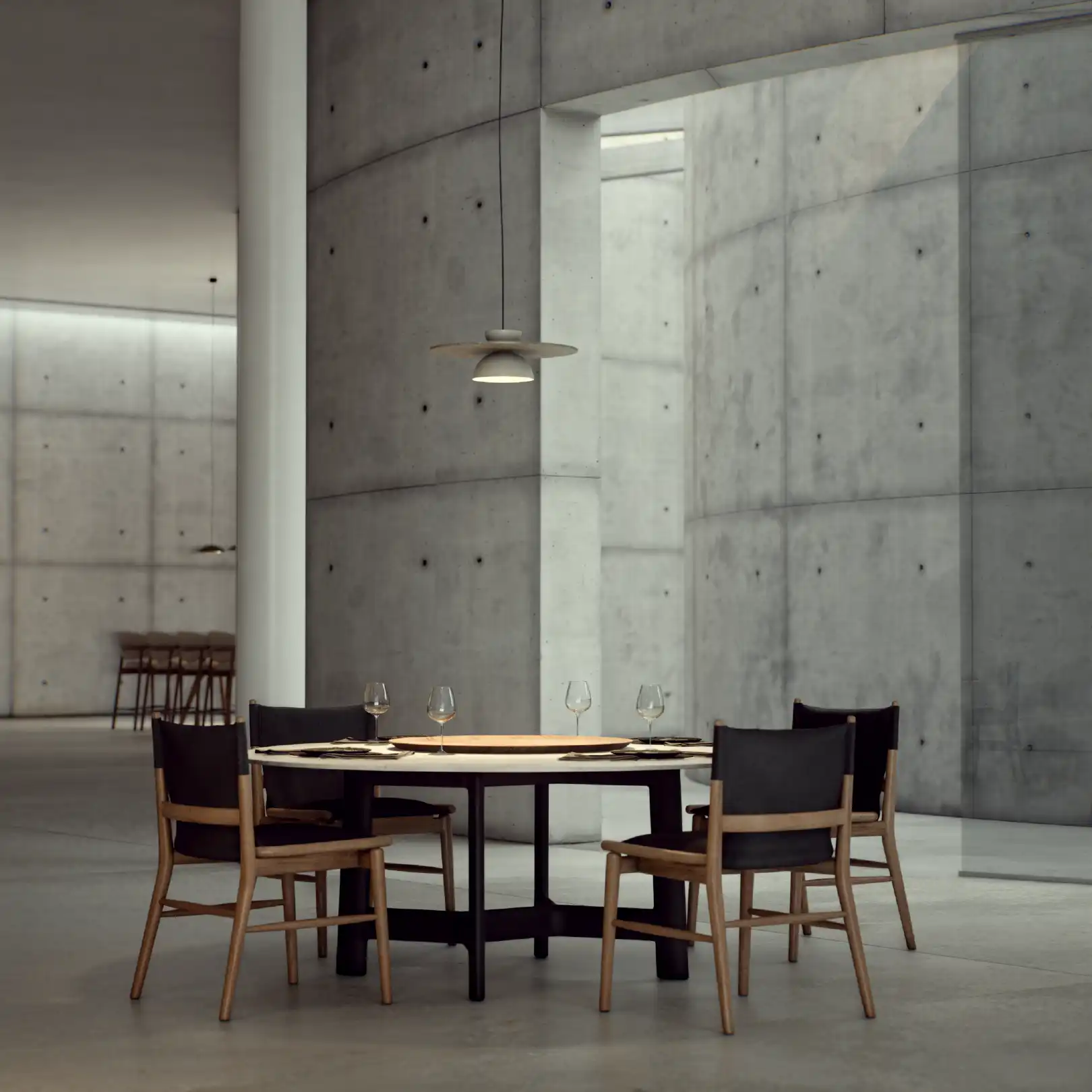 Round dining table placed inside concrete wall niche.