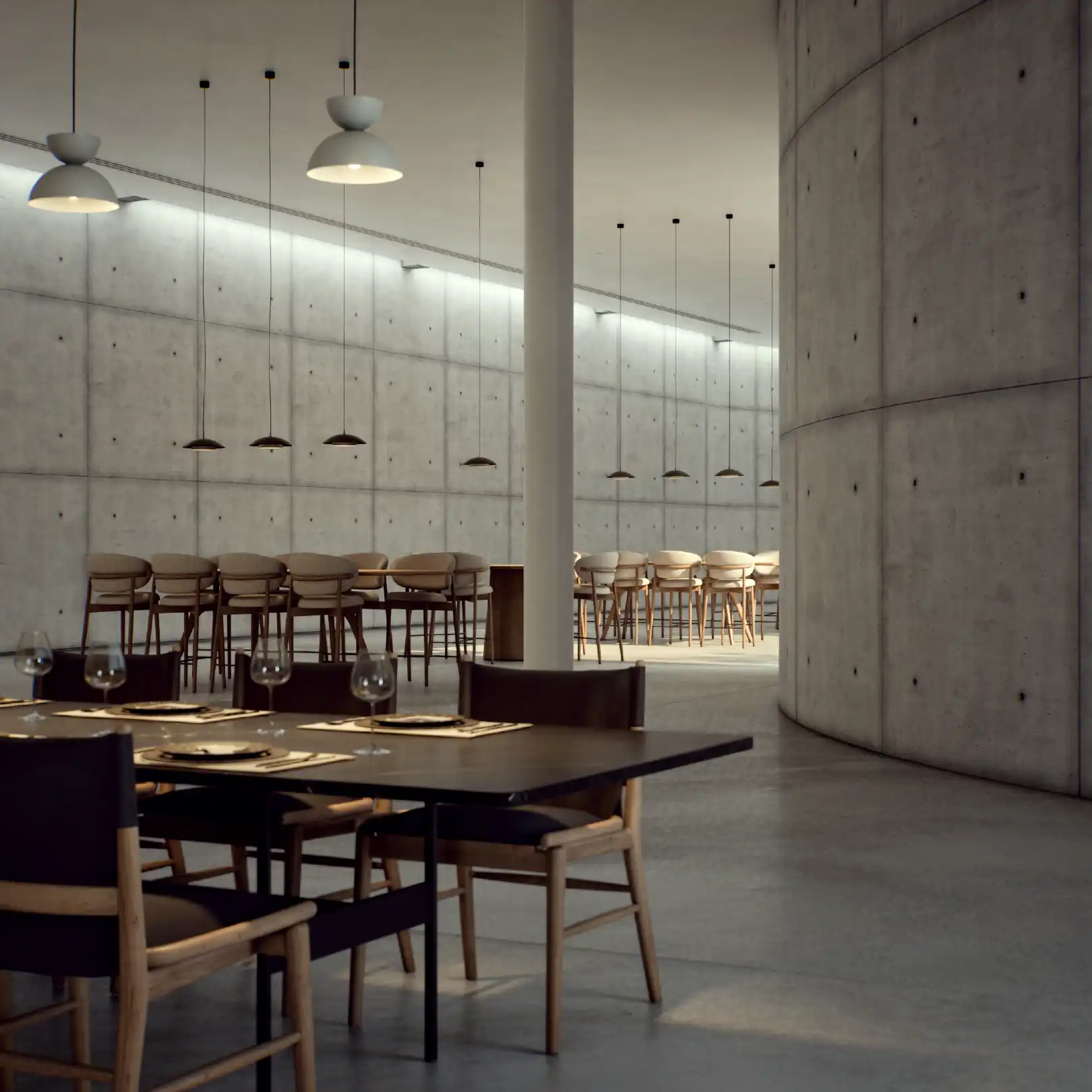 Concrete lounge area with modular sofa, low table and soft lighting.