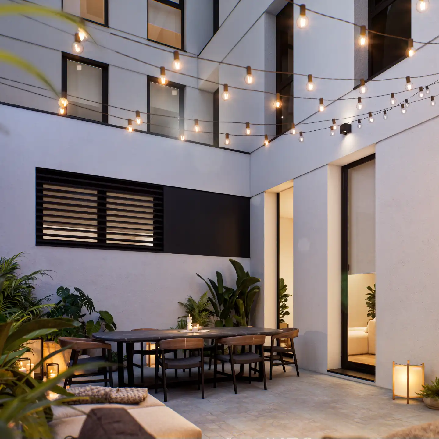 Courtyard patio with string lights, plants and evening atmosphere.