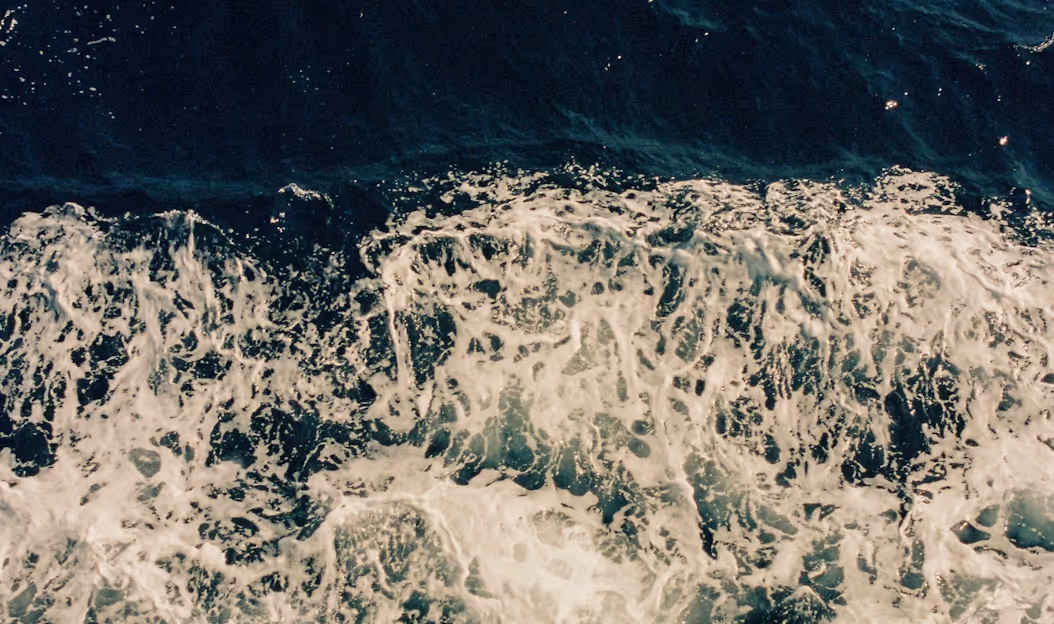 Turbulent ocean waves crashing with white foam against deep blue water