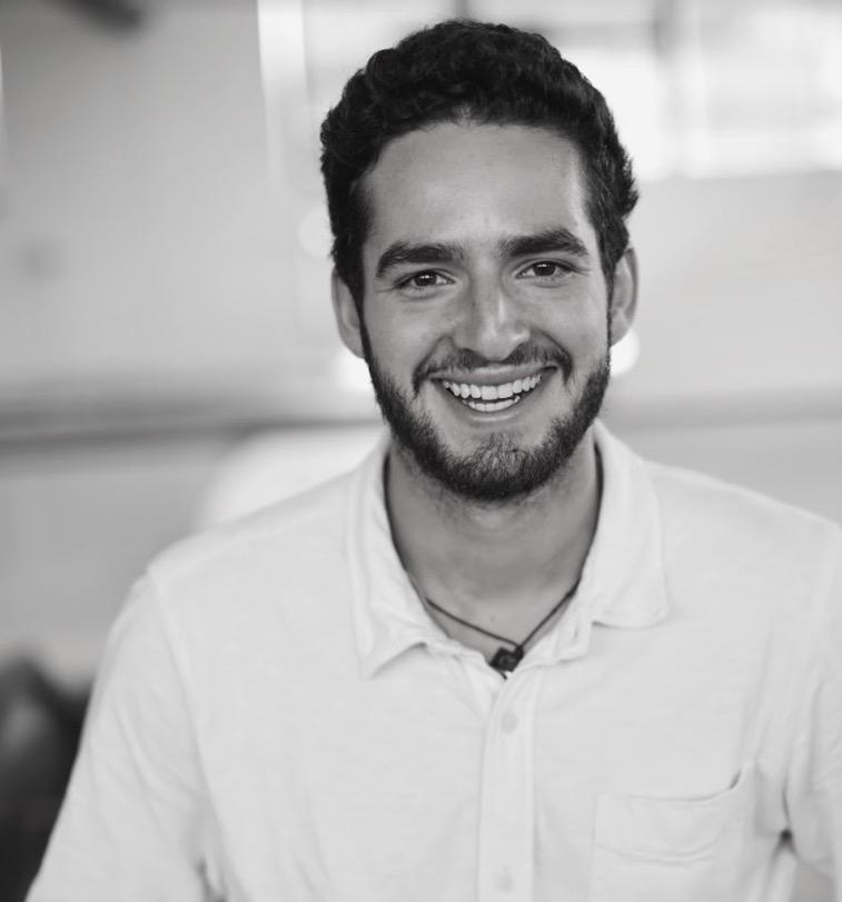 Smiling person in white shirt looking cheerful in black and white photo
