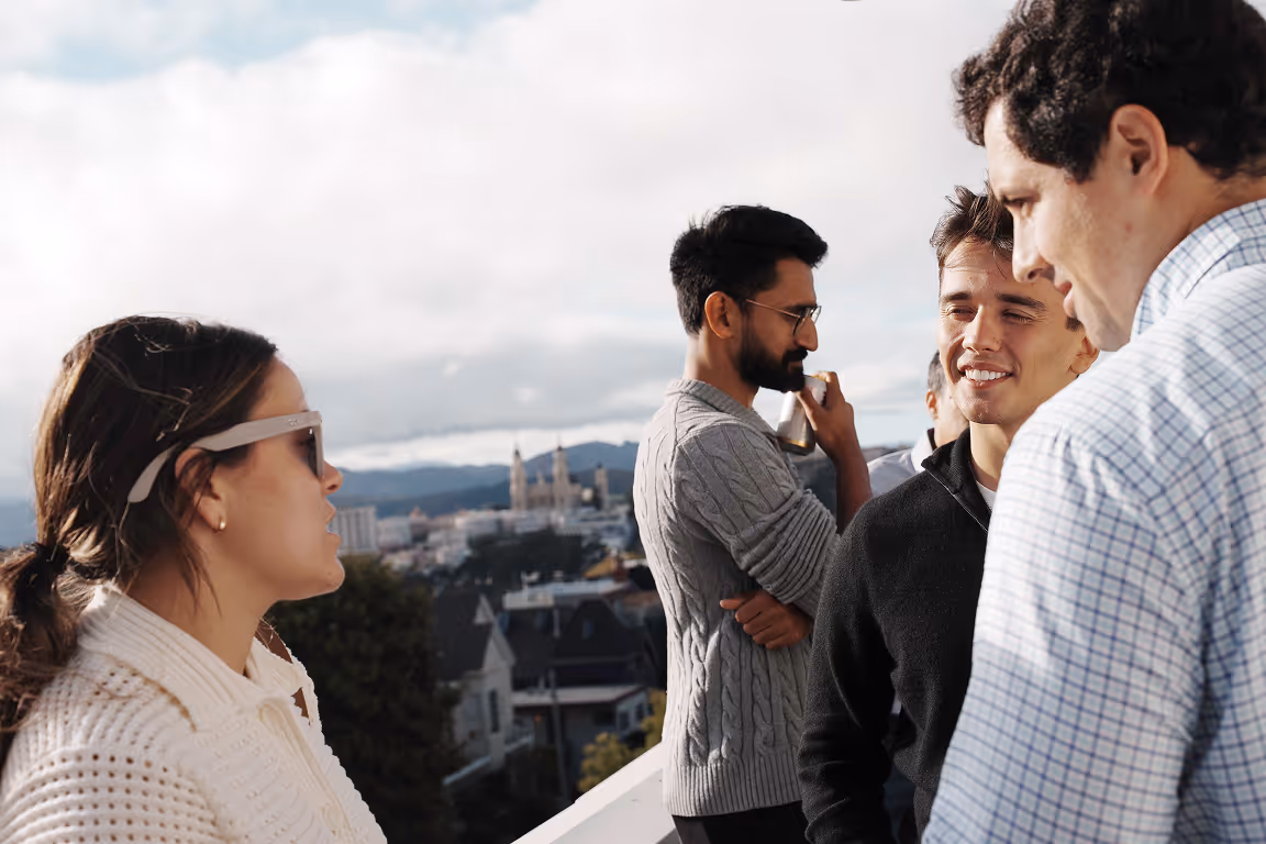 Group of colleagues chatting on rooftop with city view in background