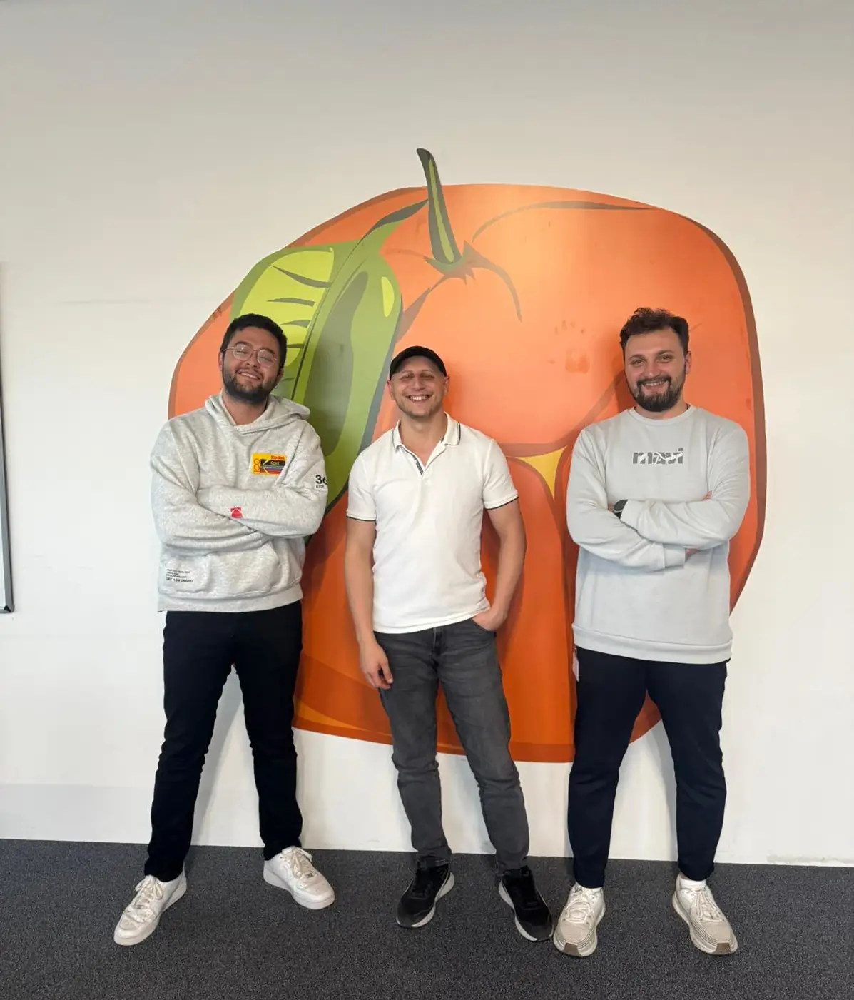 Emakin team members with Emakin logo behind them.