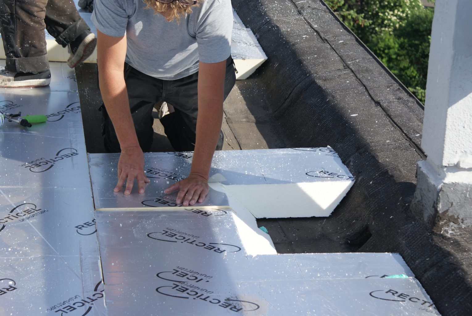 Een dakwerker legt isolatie op een dak