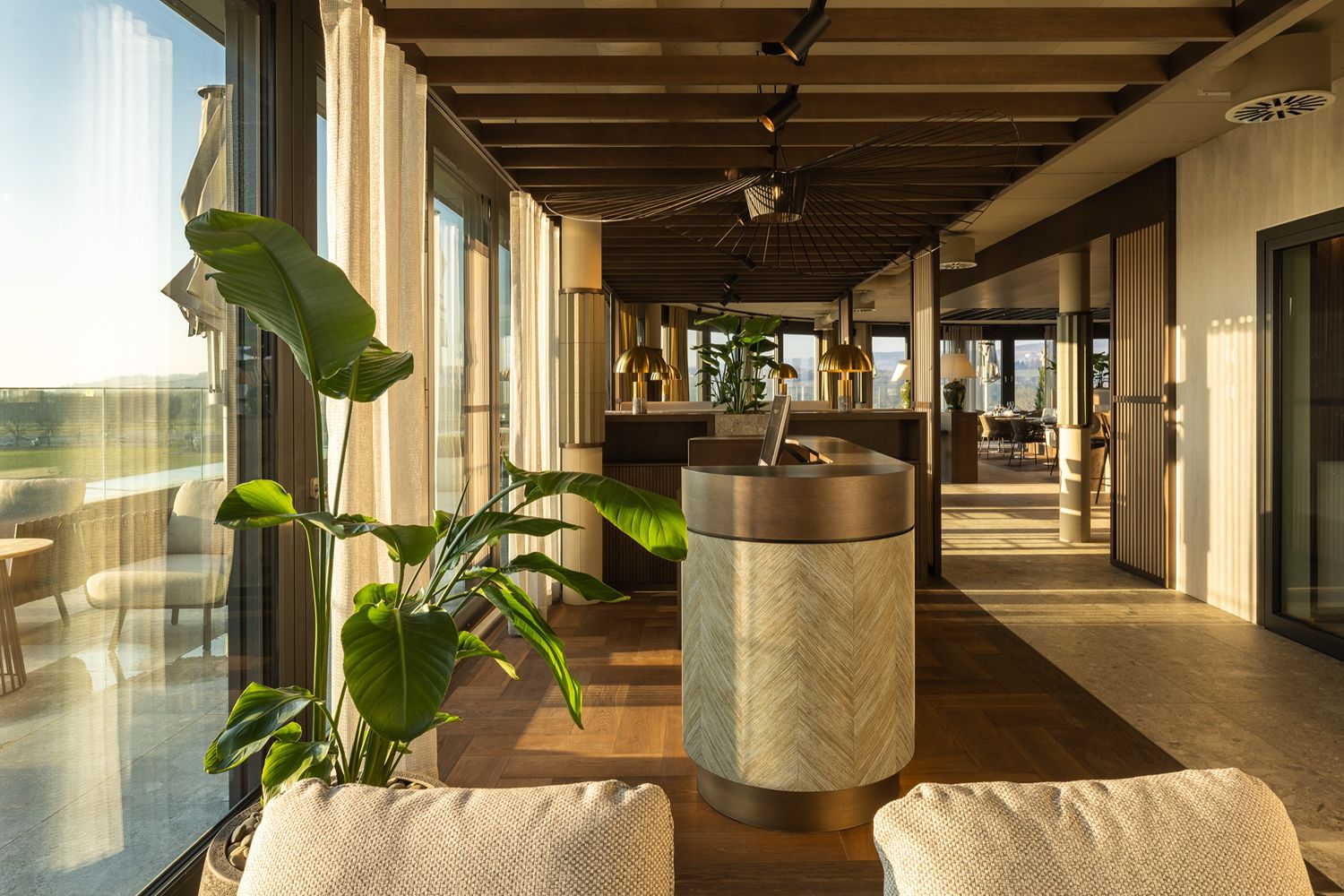 Luxuriöses, modernes Innendesign einer Bürolobby mit Pflanzen und einer natürlichen, warmen Atmosphäre.