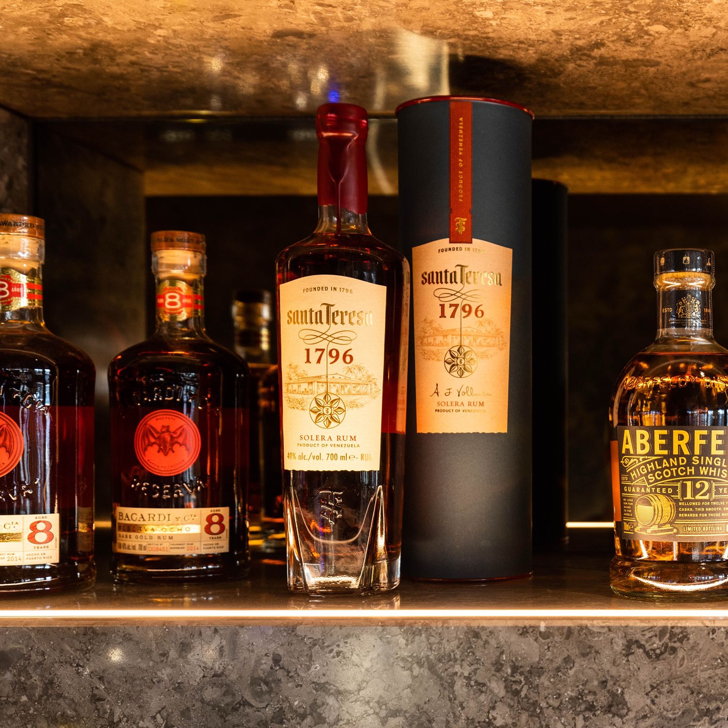 Santa Teresa-Rumflaschen, die neben verschiedenen Whisky- und Scotchflaschen auf einem Regal ausgestellt sind.