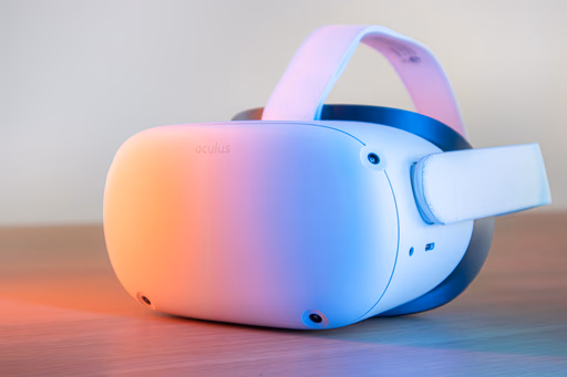 White Oculus VR headset resting on a wooden surface with soft orange and blue lighting.