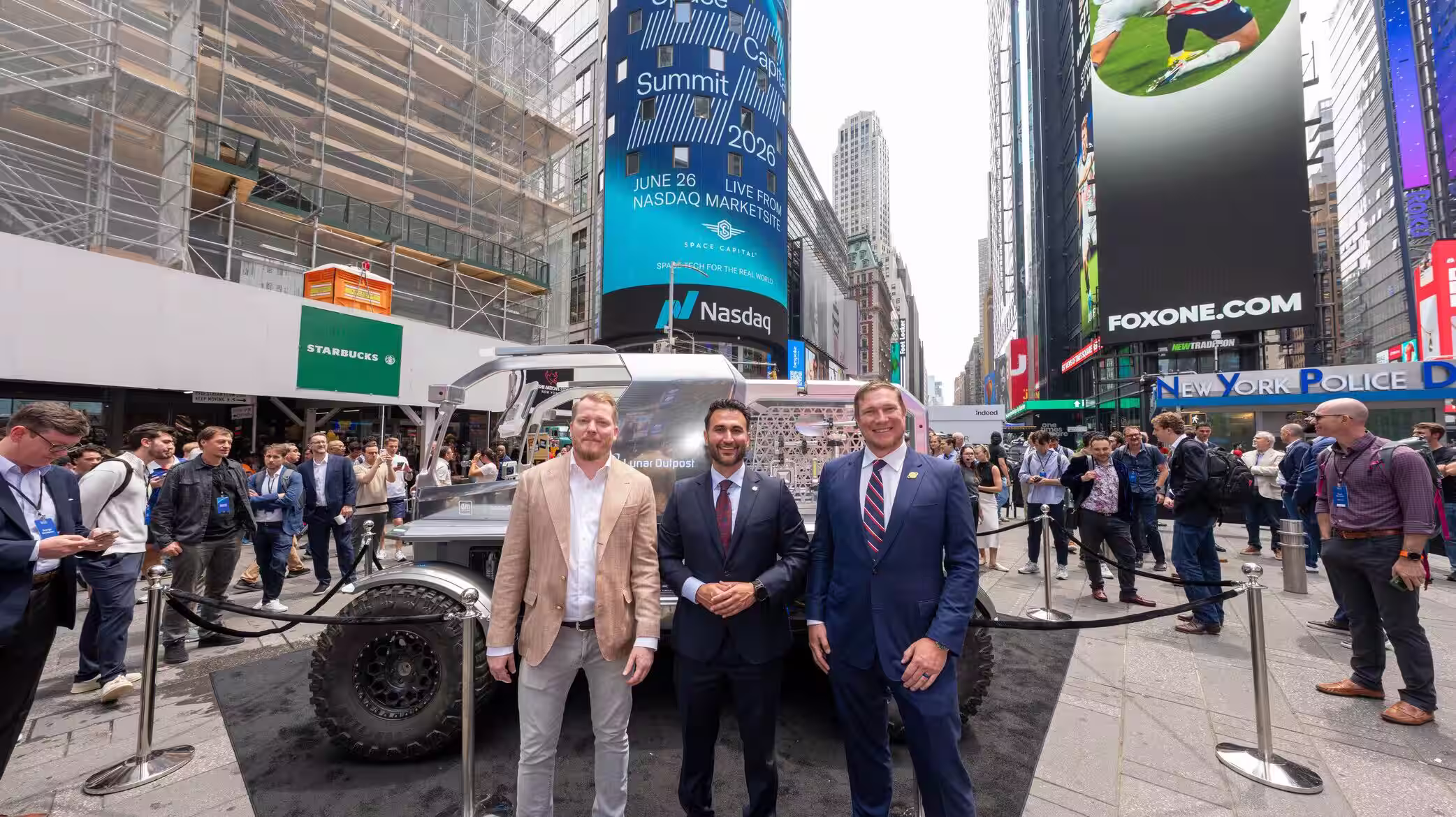 Space Capital CEO and Lunar Outpost Co-Founders with the Lunar Outpost Lunar Terrain Vehicle in Times Square during the 2026 Space Capital Summit, Nasdaq Tower branding overhead.