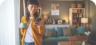 Woman in glasses and yellow cardigan smiling in modern living room