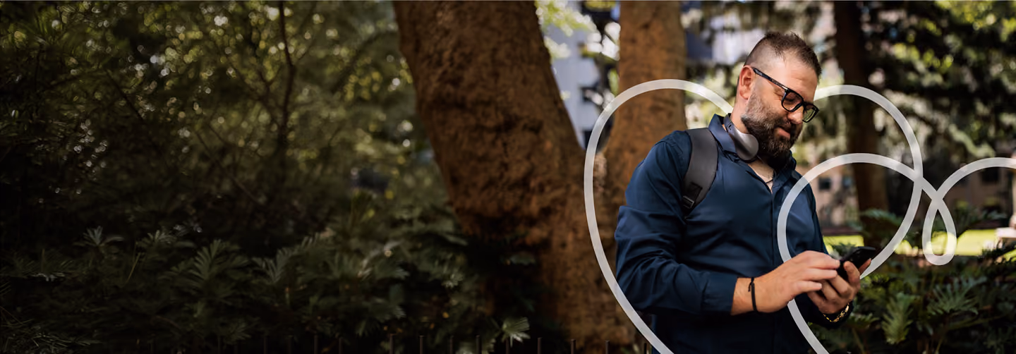Man wearing glasses holding phone in garden with decorative white circles overlaid