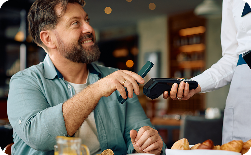 Man receiving wine bottle from server in restaurant or wine bar setting